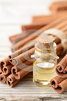 Cinnamon oil and cinnamon sticks on the wooden board