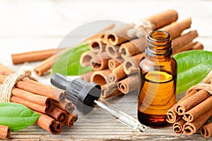 Cinnamon oil in the glass bottle, on the wooden board