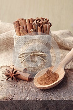 Cinnamon powder and cinnamon sticks in sackcloth bag