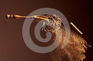 Cinnamon powder is poured out of the wooden spoon