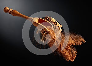 Cinnamon powder is poured out of the wooden spoon