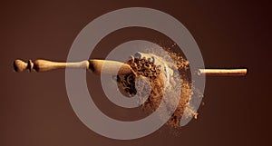 Cinnamon powder is poured out of the wooden spoon