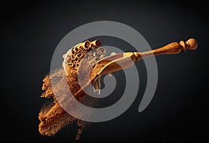 Cinnamon powder is poured out of the wooden spoon