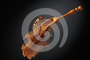 Cinnamon powder is poured out of the wooden spoon