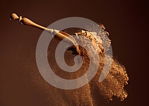 Cinnamon powder is poured out of the wooden spoon