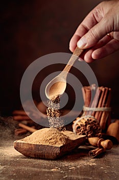 Cinnamon powder is poured into a wooden bowl