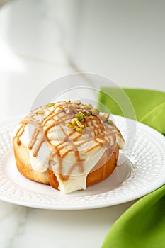 Cinnamon roll bun with icing on plate