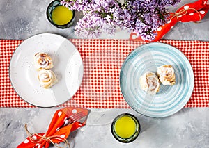 Cinnamon roll or cinnabon with white cream glaze on plate on concrete background. Traditional homemade sweet buns