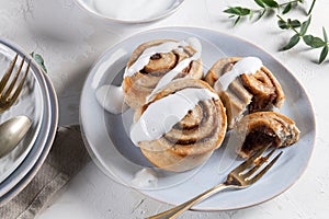 Cinnamon rolls or cinnabon  with icing for Christmas. Homemade traditional winter festive dessert buns. Pastry food for breakfast