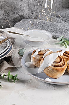 Cinnamon rolls or cinnabon  with icing for Christmas. Homemade traditional winter festive dessert buns. Pastry food for breakfast