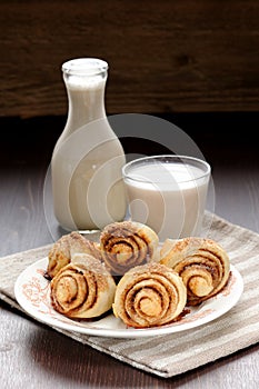 Cinnamon rolls with glass and bottle of milk