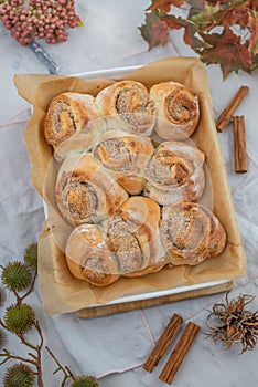 Cinnamon rolls with sugar frosting. With cinnamon sticks and spices, wooden background