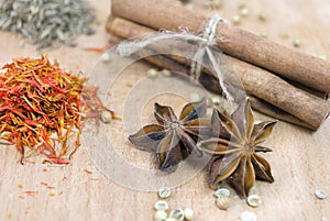 Cinnamon, safron, star anise and peper on a wooden table photo