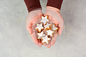 Cinnamon stars, Zimtsterne traditional german christmas cookies in the hands, gingerbread with anise spice for holidays