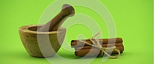 Cinnamon sticks bundle and wooden mortar with pestle