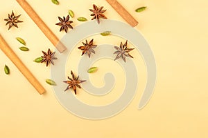 Cinnamon sticks, cardamom and star anise on a beige background, top view