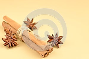 Cinnamon sticks, cardamom and star anise on a beige background, top view