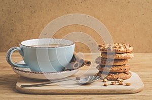 cinnamon sticks, cookies with nuts and a cup of coffee/cinnamon sticks, cookies with nuts and a cup of coffee on a wooden tray.