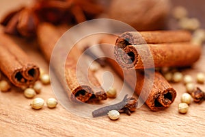 Cinnamon sticks and Dry coriander seeds on wood