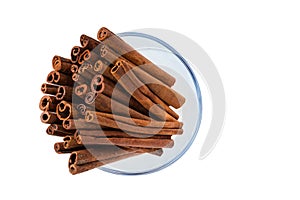 Cinnamon sticks in a glass bowl on white background,macro shot