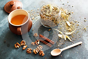 Cinnamon sticks, nuts and a herb collection scattered on a blue