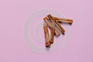 Cinnamon sticks on pink millennial background. It tastes and smells good