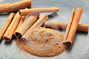 Cinnamon sticks with powder on dark background