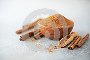 Cinnamon sticks and powder on grey background. Spices for ayurvedic treatment. Alternative medicine concept