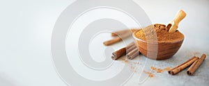 Cinnamon sticks and powder on grey background. Spices for ayurvedic treatment. Alternative medicine concept