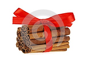 Cinnamon sticks with red ribbon on white background