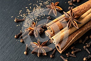 Cinnamon sticks, star anise and cloves on black background photo