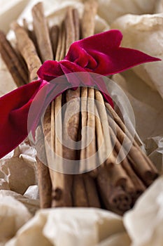 Cinnamon sticks tied with a red ribbon in wrapped paper