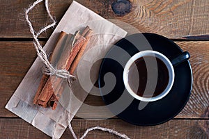 Cinnamon sticks tied with a rope lie on a wooden table. photo