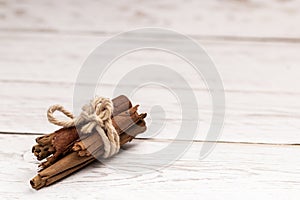 Cinnamon sticks tied on wooden table