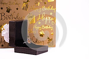 Cinnamon stone ring in lather gift box and carry bag on white background. Happy birthday concept