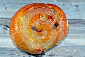 Cinnamon swirl puff roll sweetened with honey and raisins and filled with custard cream baked, selective focus of pastries