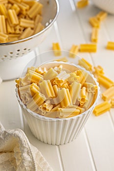 Cinque buchi. Uncooked italian pasta in bowl on white table