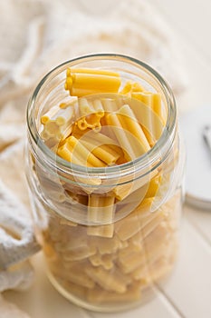 Cinque buchi. Uncooked italian pasta in jar on white table