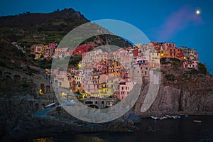 Cinque Terre, Italy - night view of the colorful pastel houses in Manarola, a seaside village on the rugged Italian Riviera coast.