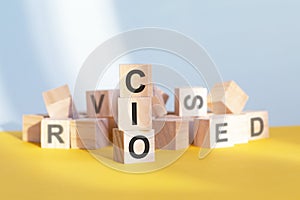 CIO written on wooden cubes, yellow background