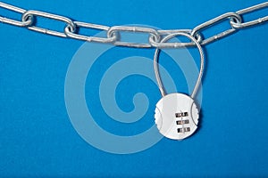 Cipher padlock on chain on blue background. Security concept.