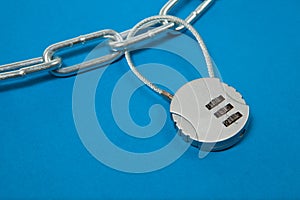 Cipher padlock on chain on blue background. Security concept