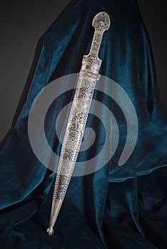 Circassian Adyghe Kama silver dagger on velvet dark material. photo