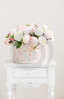 Circkle box with bouquet of roses on a wooden table.