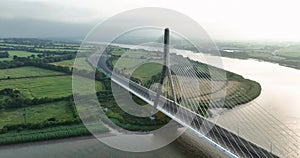 A circle around a massive bridge. A massive cable-stayed bridge against a backdrop of green fields
