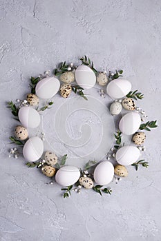 Circle border for easter card or invitation. Easter wreath with easter quail, chicken eggs and leaf sprigs of eucalyptus. On a gra