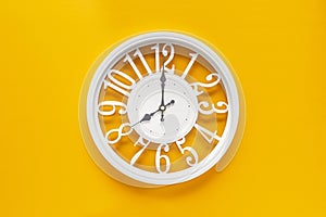 Circle clock on yellow background wall