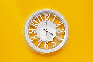 Circle clock on yellow background wall