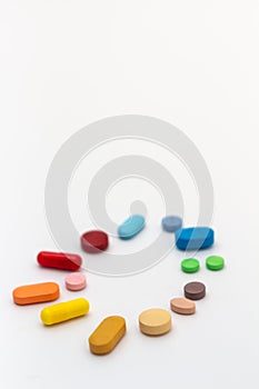 Circle of colored pills on white background. Legal drugs from the pharmaceutical industry