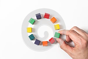 Circle of colorful wooden blocks representing unity of diverse elements or people.